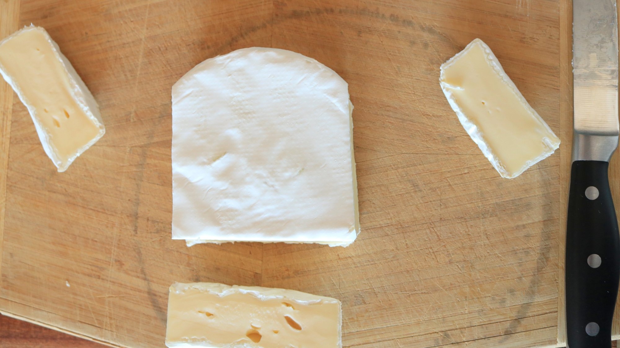 A wheel of brie with the sides and bottom cut off.