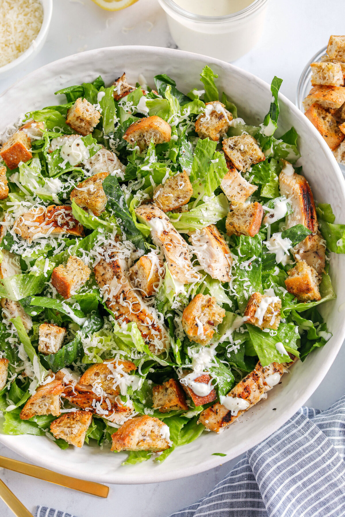 The BEST Healthy Chicken Caesar Salad made with grilled lemon chicken, garlicky homemade croutons, fresh parmesan cheese and tossed with a lightened up Greek yogurt dressing!