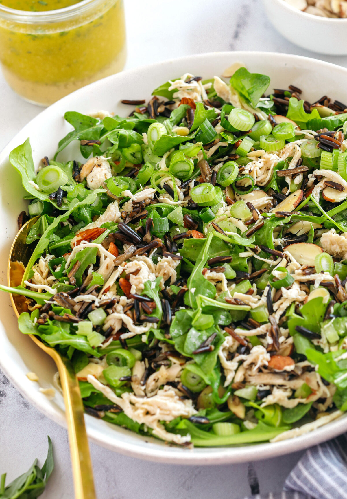 Hearty and delicious Wild Rice Chicken Salad made with leafy arugula, warm wild rice, shredded chicken, sliced almonds, and green onions all tossed with a bright lemon tarragon vinaigrette!